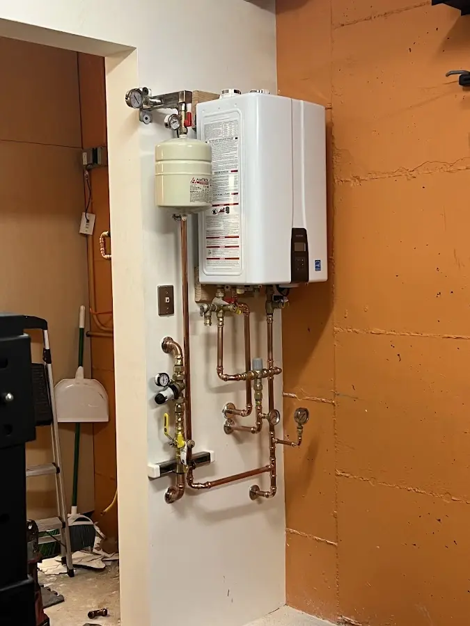 Plumbing technician inspecting water heater connections in Pittstown